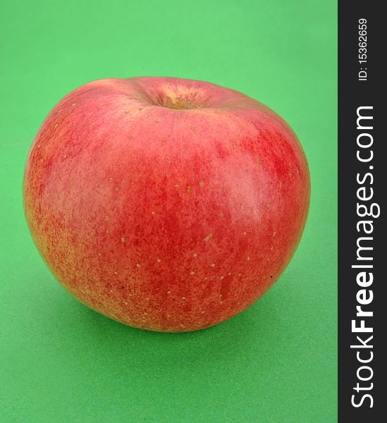 Ripe red apple. Isolated on a green background