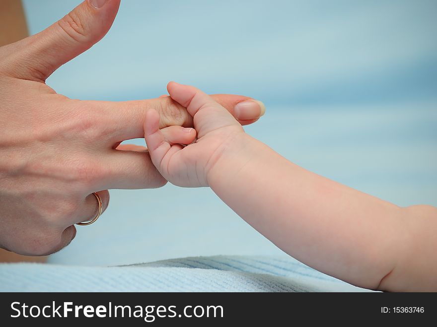 The baby has grasped a finger of mum. The baby has grasped a finger of mum