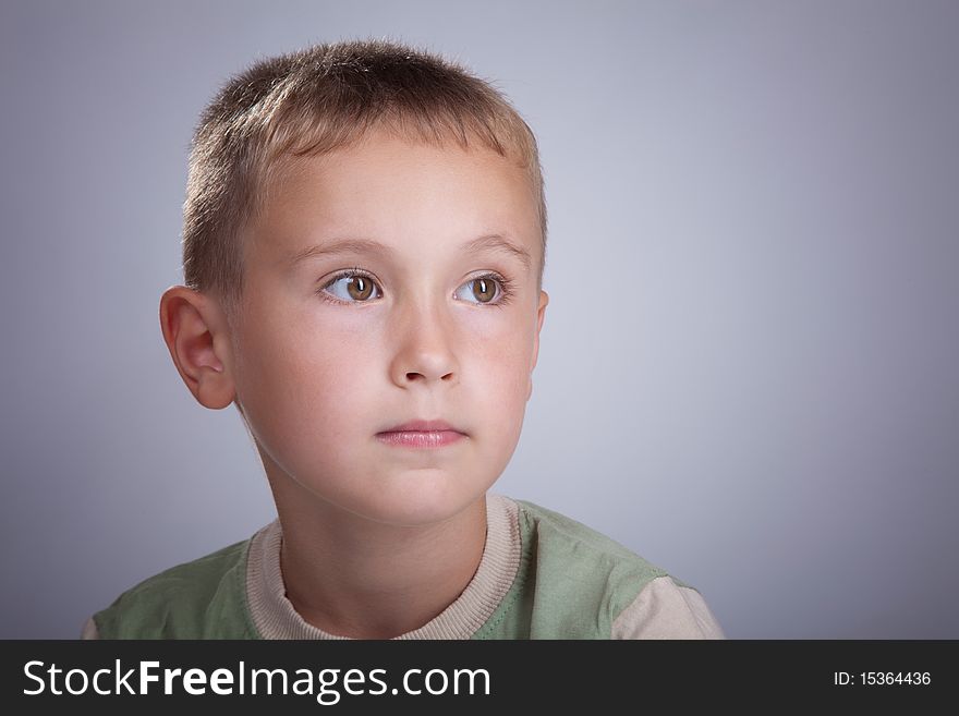 Serious young blonde boy in photo studio portrait. Serious young blonde boy in photo studio portrait