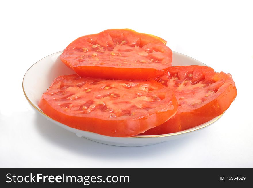 Three large round piece of ripe juicy tomato on a porcelain dish, a vegetable red on a white background. Three large round piece of ripe juicy tomato on a porcelain dish, a vegetable red on a white background