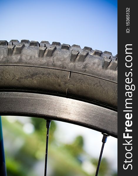 Mountain bike wheel closeup outdoors with blurred background. Mountain bike wheel closeup outdoors with blurred background