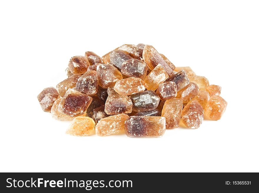 A heap of brown candy sugar crystals isolated on white. A heap of brown candy sugar crystals isolated on white