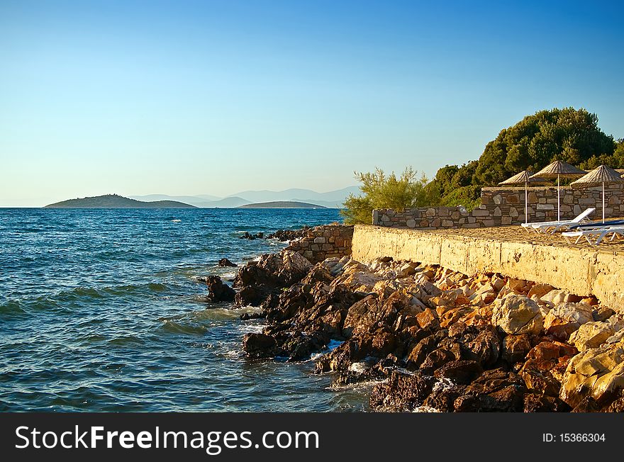 Beach at the Aegean sea with beach chairs and umbrellas. Beach at the Aegean sea with beach chairs and umbrellas