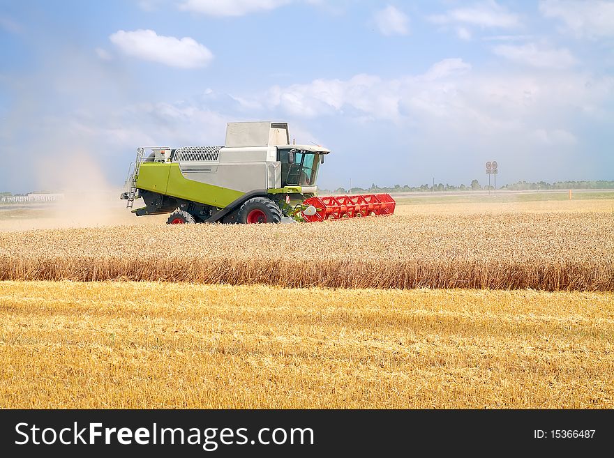 Modern combine harvester working on a wheat crop. Modern combine harvester working on a wheat crop