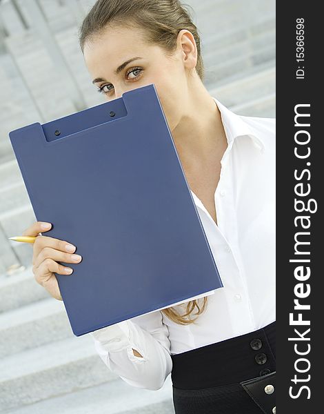 Attractive young businesswoman smiling with a folder. Attractive young businesswoman smiling with a folder