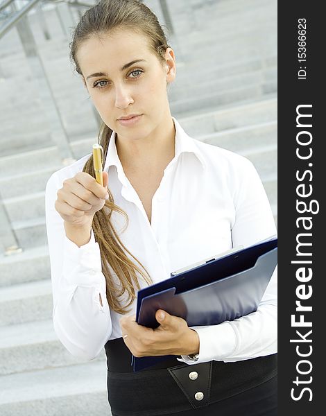 Attractive young businessman smiling with a folder and a gold handle. Conducted survey. Attractive young businessman smiling with a folder and a gold handle. Conducted survey