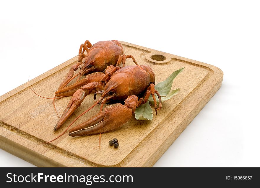 Two boiled lobster on a cutting board on an isolated white background. Two boiled lobster on a cutting board on an isolated white background.