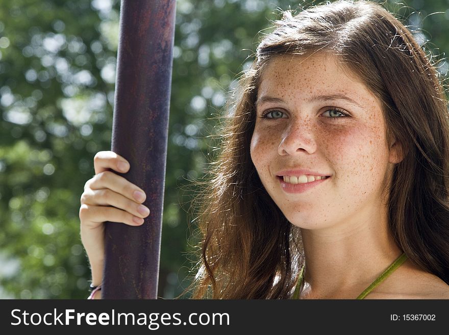 A pretty smiling freckled faced teenage girl with sunlit hair and green eyes gazes off into the distance. A pretty smiling freckled faced teenage girl with sunlit hair and green eyes gazes off into the distance.