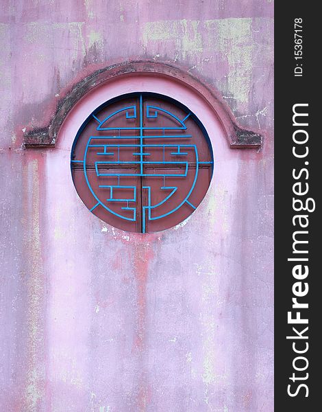 Circle chinese style window on the red wall ,vertical