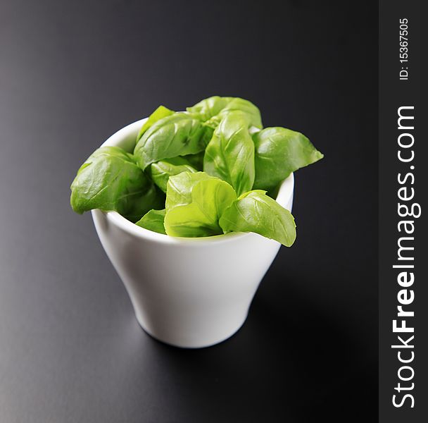 Fresh basil leaves in a porcelain cup