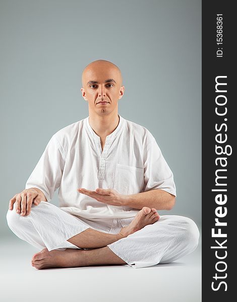 Male sitting with legs crossed, practicing thai meditating, looking at camera. Male sitting with legs crossed, practicing thai meditating, looking at camera