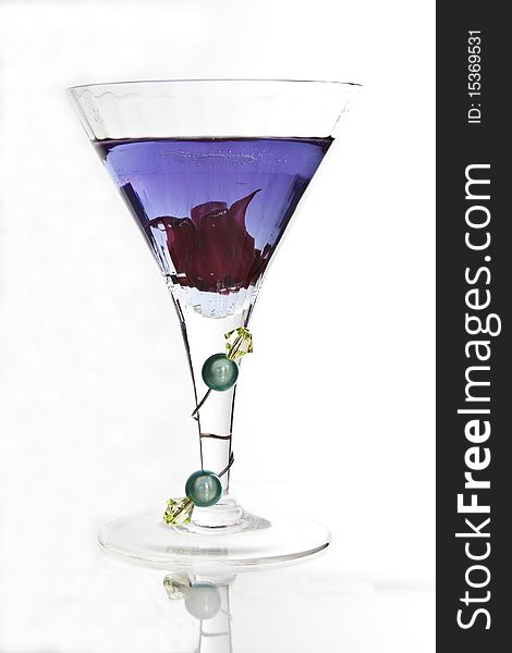 A cocktail glass with decorated glass stem containing a violet drink. A cocktail glass with decorated glass stem containing a violet drink