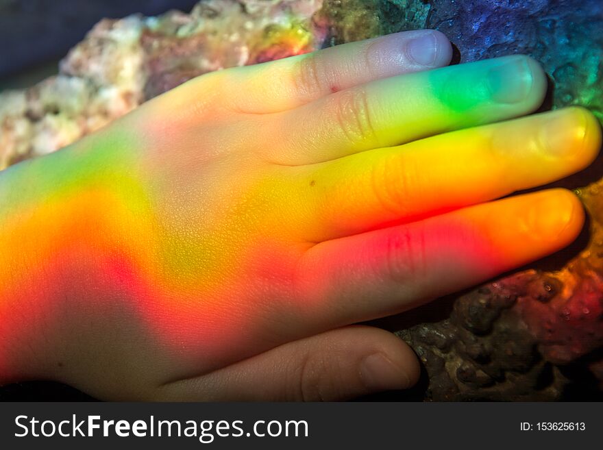 Rainbow colors are displayed on the baby`s hand