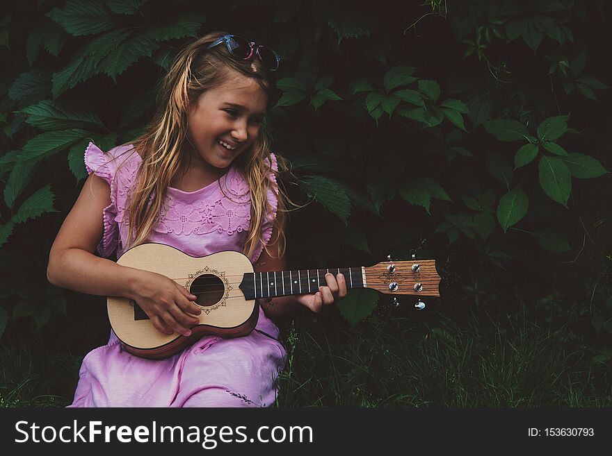 Beautiful young girl with ukulele