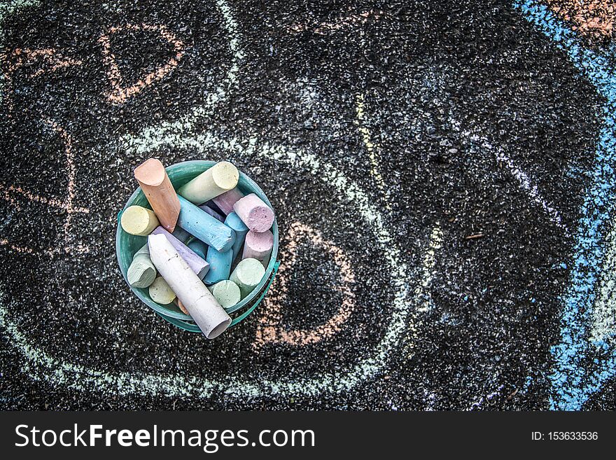 A picture of colorful chalk drawings on a sidewalk in the summer