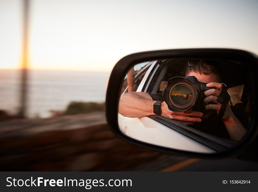 Man With Camera Taking Photo In Car Wing Mirror