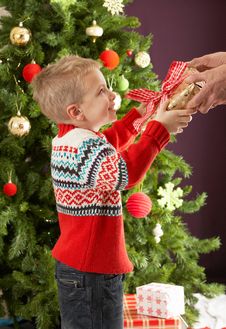 Boy Holding Present In Front Of Christmas Tree Royalty Free Stock Photography Boy Holding Present In Front Of Christmas Tree Royalty Free Stock Photography