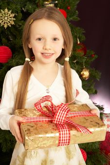 Girl Holding Christmas Present In Front Of Tree Royalty Free Stock Photo Girl Holding Christmas Present In Front Of Tree Royalty Free Stock Photo