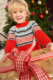 Young Boy Holding Gift In Front Of Christmas Tree Royalty Free Stock Images Young Boy Holding Gift In Front Of Christmas Tree Royalty Free Stock Images