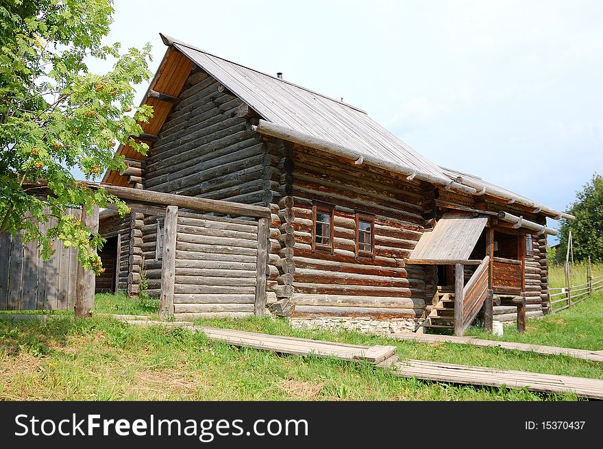 Traditional russian rural house at midday with green grass