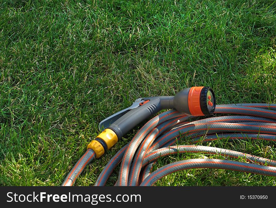 Device of irrigation garden. Irrigation system - technique of watering in the garden. Hose for manual watering the lawn or garden. Device of irrigation garden. Irrigation system - technique of watering in the garden. Hose for manual watering the lawn or garden.