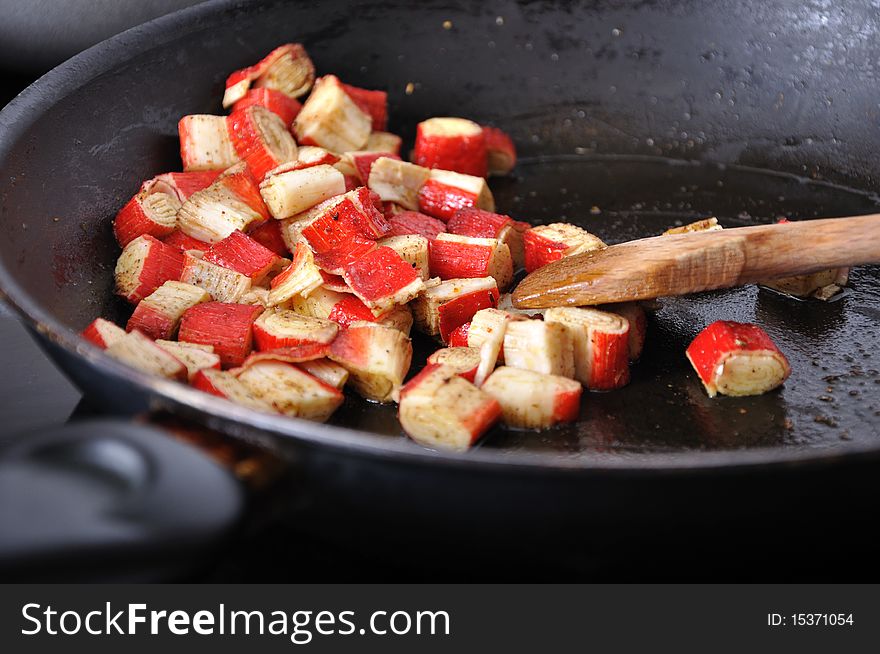 Pile of surami cube on olive oil in black pan. Pile of surami cube on olive oil in black pan