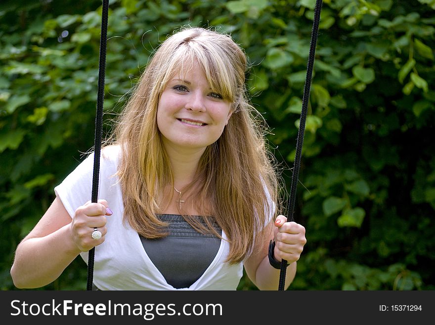 Girl smiling and looking happy on a swing. Girl smiling and looking happy on a swing