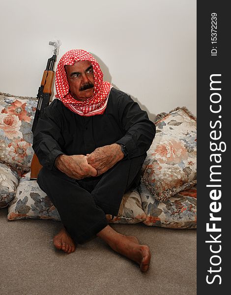 Moroccan  Militia  Man sitting with his AK 47 rifle at home. Moroccan  Militia  Man sitting with his AK 47 rifle at home.