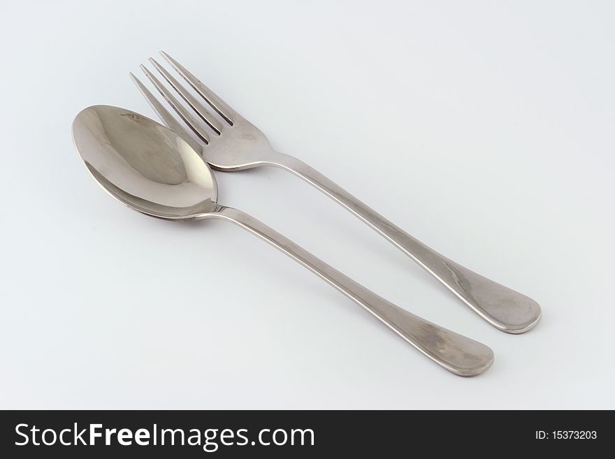 Image of a fork and a spoon over a white background. Image of a fork and a spoon over a white background