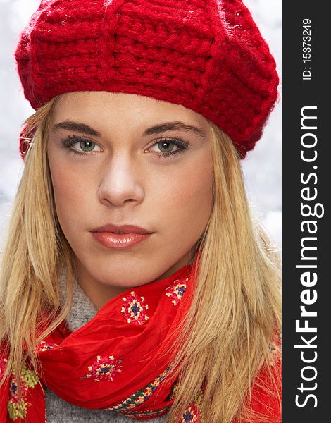 Fashionable Teenage Girl Wearing Cap And Knitwear In Studio In Front Of Christmas Tree