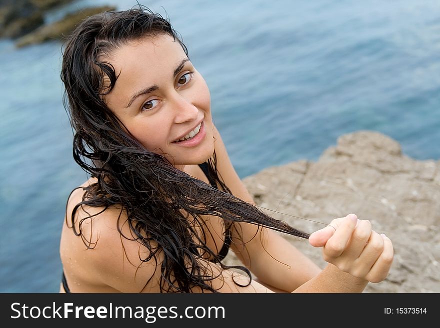 Close-up of the young pretty girl with wet hair near the sea. Close-up of the young pretty girl with wet hair near the sea