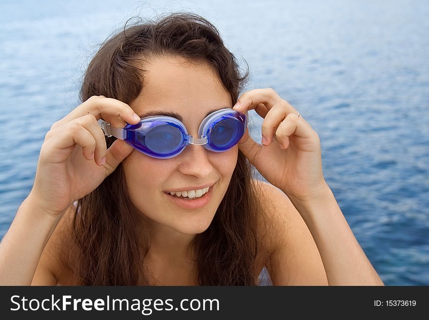 Young girl with swimming glasses near the sea