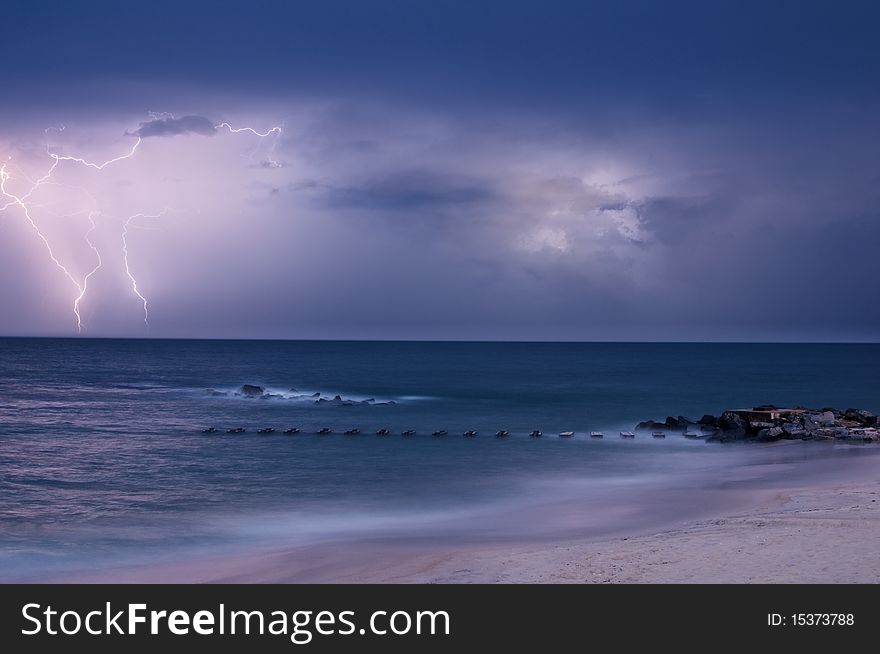 Lightning strike over blue ocean water
