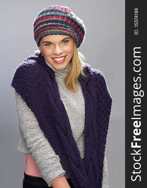 Teenage Girl Wearing Warm Winter Clothes In Studio Smiling