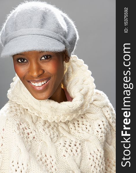 Fashionable Woman Wearing Knitwear And Cap In Studio Smiling. Fashionable Woman Wearing Knitwear And Cap In Studio Smiling