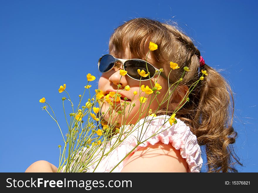 Portrait of the beautiful girl in sun glasses with a bouquet from yellow wild flowers against the sky. Portrait of the beautiful girl in sun glasses with a bouquet from yellow wild flowers against the sky