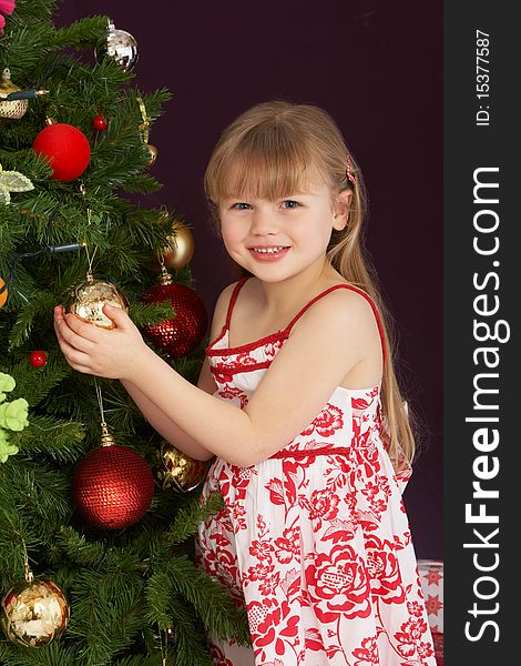 Young Girl Decorating Christmas Tree Smiling At Camera