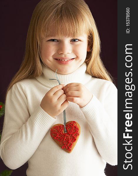 Young Girl Holding Heart Shaped Cookie In Studio