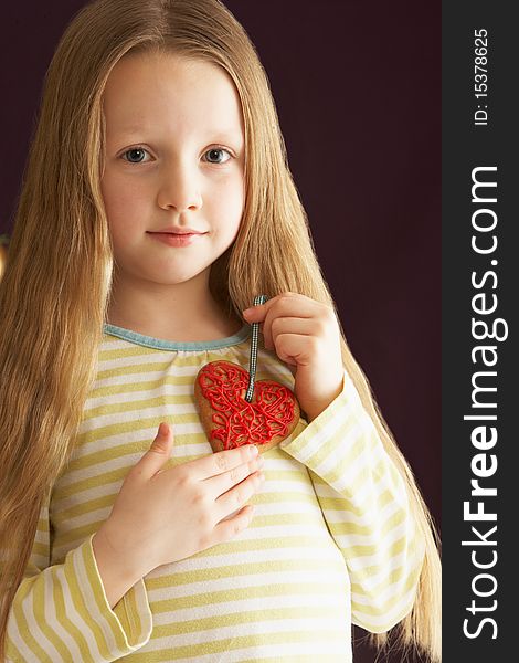 Young Girl Holding Heart Shaped Cookie In Studio