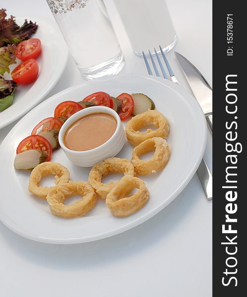 Fried calamary served with salad and trafitional greek drink ouzo