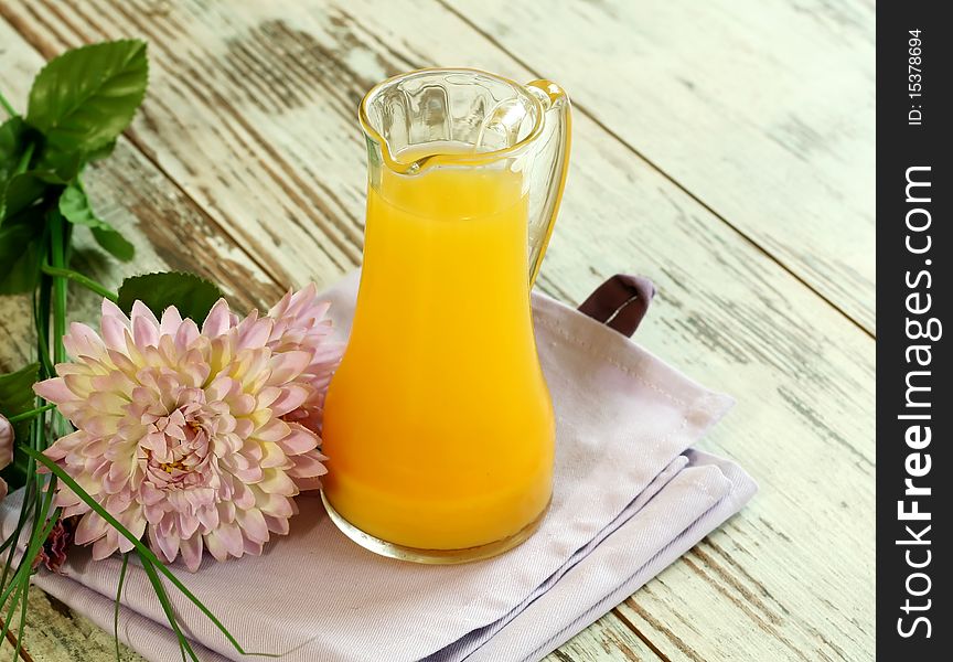 Orange juice in glass on wooden boards