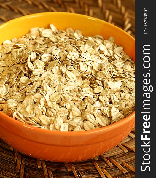 Oats in yellow bowl on a wooden background. Oats in yellow bowl on a wooden background