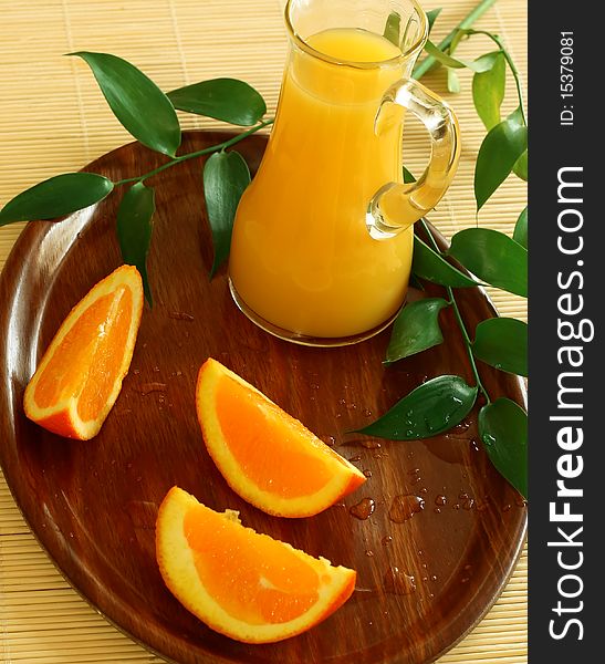 Fresh oranges and orange juice in glass on wooden