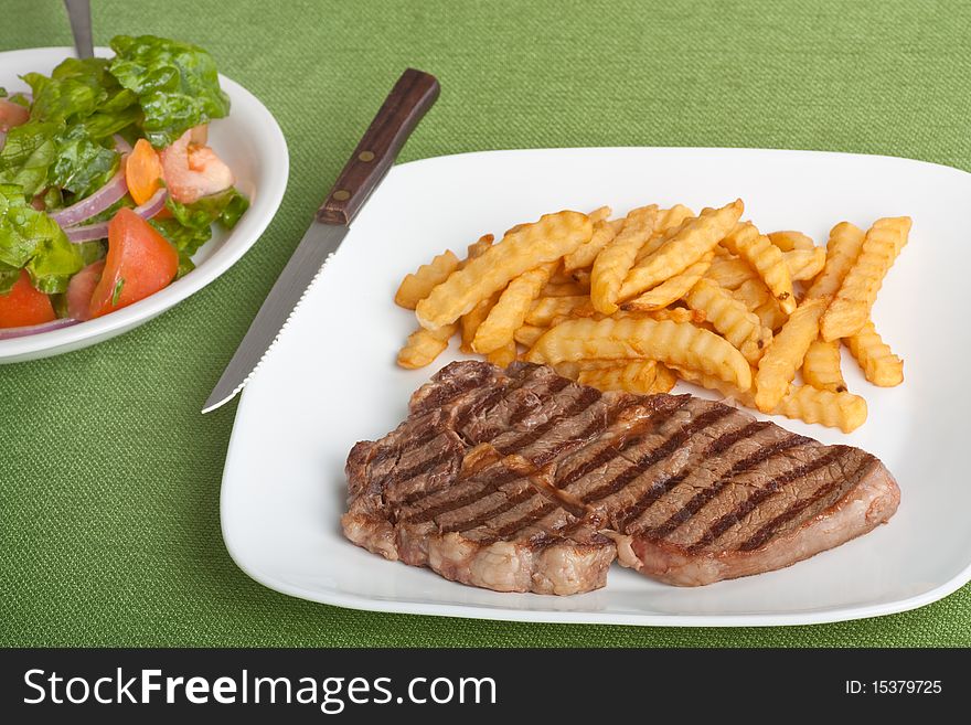 Steak and french fries meal with a tossed salad. Steak and french fries meal with a tossed salad