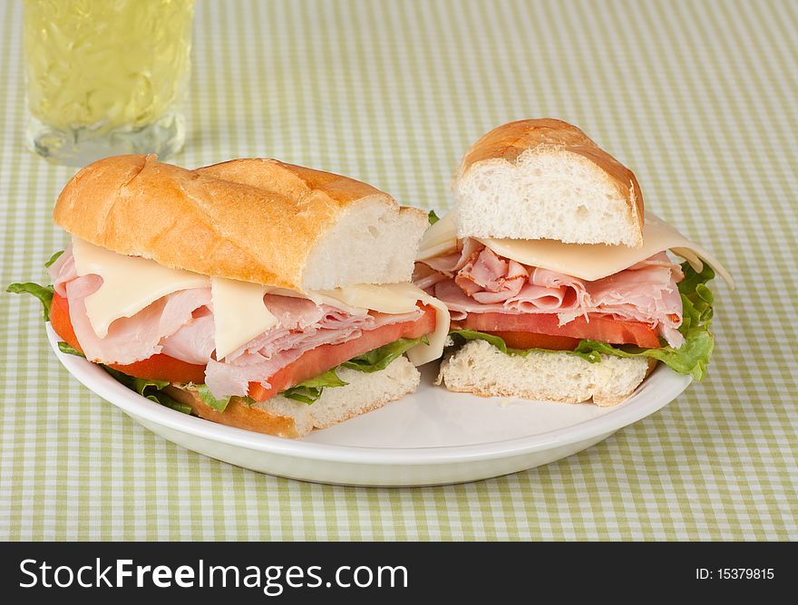 Ham and swiss cheese sub sandwich with lettuce and tomato and a drink. Ham and swiss cheese sub sandwich with lettuce and tomato and a drink