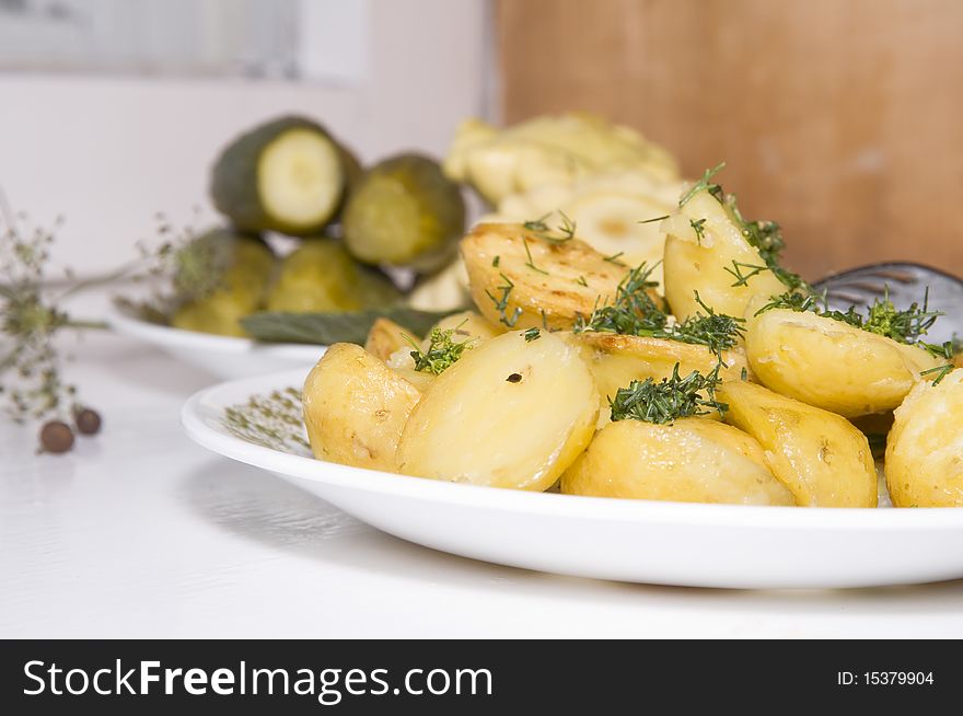 Young fried potatoes with pickles and Patison on the white background