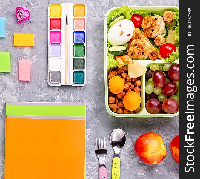 School lunchbox with healthy snack and funny foods- cutlets, vegetables, fruits, nuts. Back to school background. School lunchbox with healthy snack and funny foods- cutlets, vegetables, fruits, nuts. Back to school background