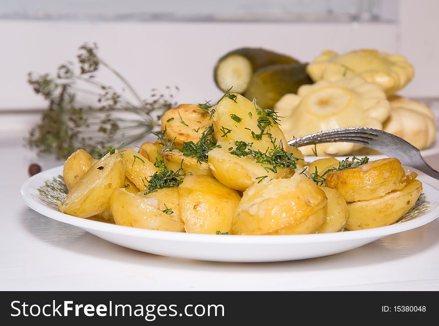 Young fried potatoes with pickles and Patison on the white background