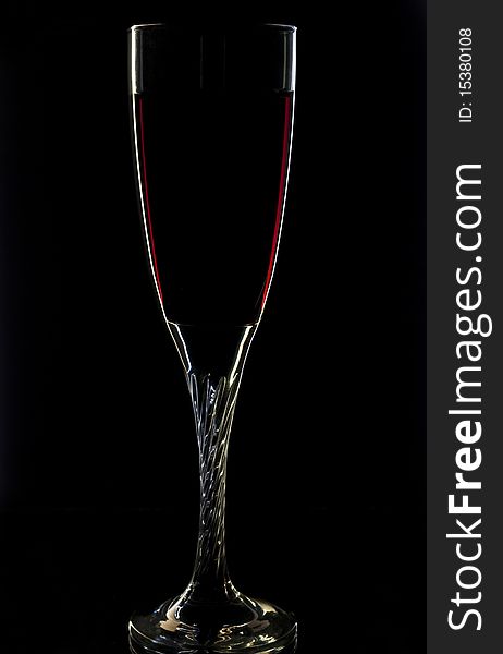 A glass of red wine on black background. A glass of red wine on black background.
