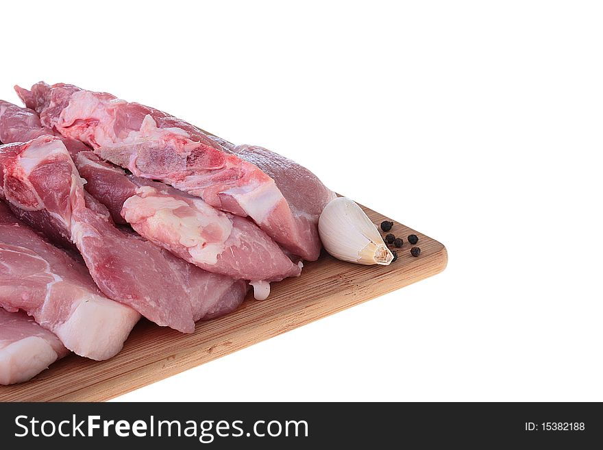 Piece of crude meat with black pepper on a kitchen board. Piece of crude meat with black pepper on a kitchen board.